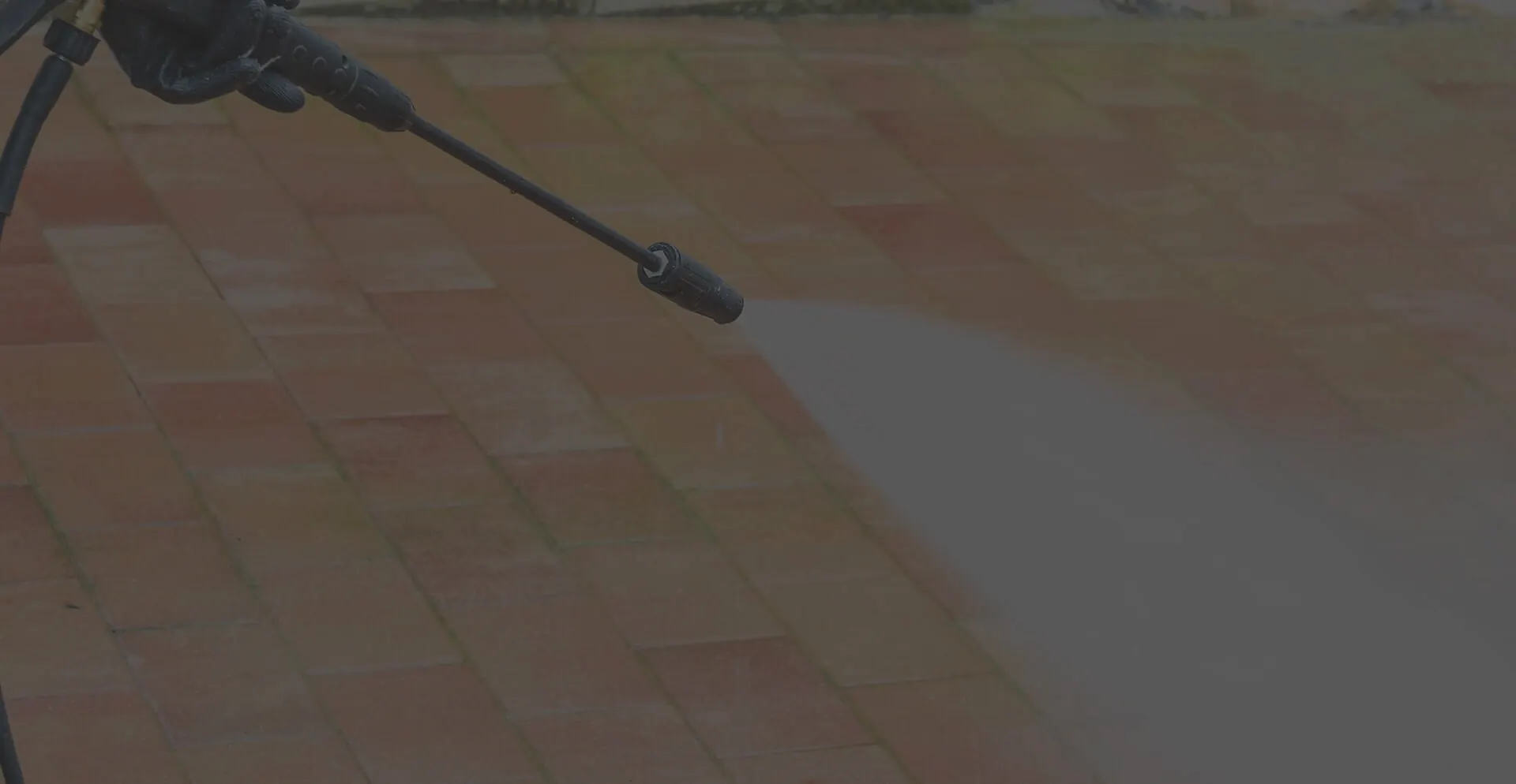 Professional pressure washing a paved patio in the Outer Banks
